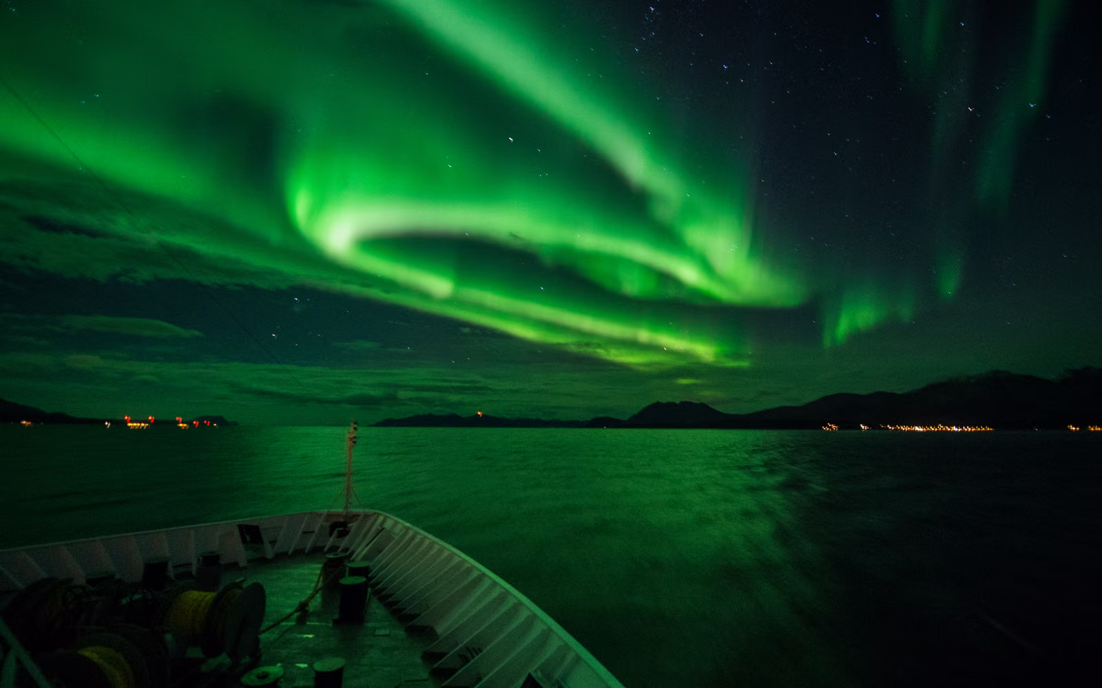 The Northern Lights over the bow of a Hurtigruten ship